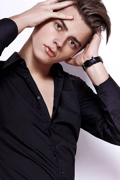 Egy fiatal srác egy fekete ing, kiegyenesíti haj — Stock Fotó