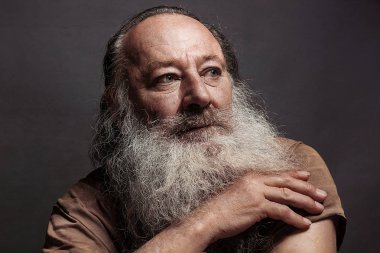 yaşlı adam altmış, yetmiş, karanlık bir arka plan üzerinde büyük bir gülümseme ile uzun sakallı