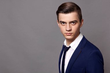 Stüdyoda mavi ceketli ve kravatlı bir adam var.