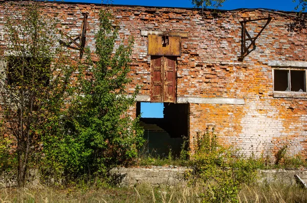 Кирпичная стена заброшенной мастерской — стоковое фото