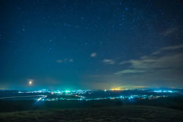 Natt by på en bakgrund av stjärnor — Stockfoto