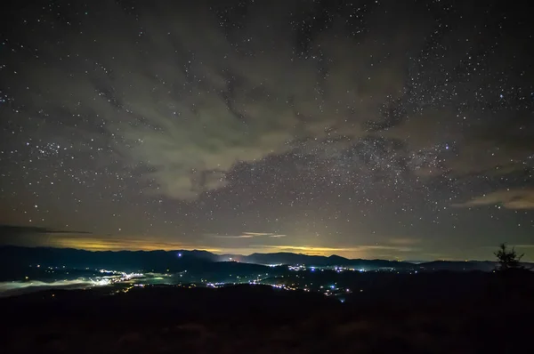 Céu estrelado sobre a cidade no nevoeiro — Fotografia de Stock