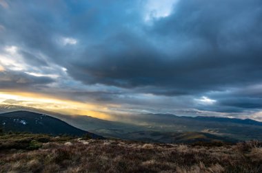 Dağlarda gün batımında fırtınalı gökyüzü