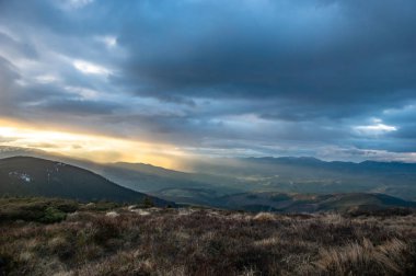 Dağlarda gün batımında güneş ışınları