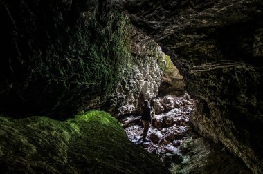 Karst mağarasının çıkışındaki adam.