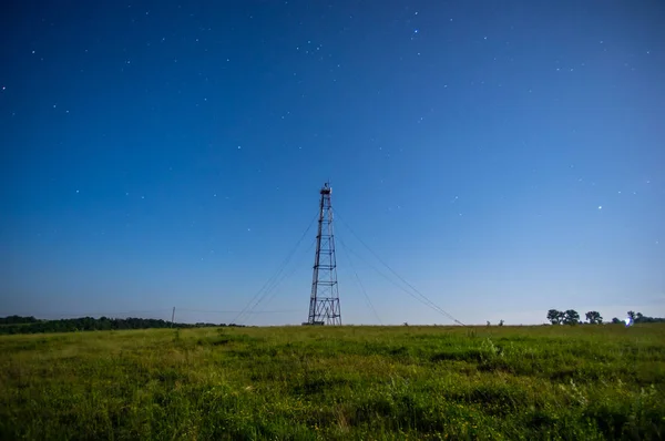 Torre de telecomunicações contra o céu estrelado no campo — Fotografia de Stock