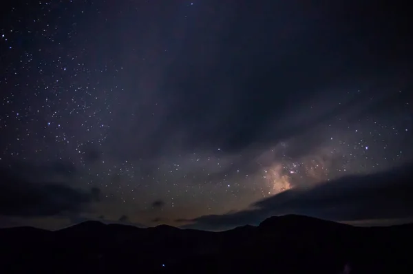 Wolken in de nachtelijke hemel tegen de achtergrond van de Melkweg — Stockfoto