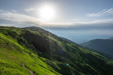 Dağlarda gün doğumunda güneş ışınları
