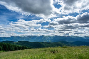 Dağlarda mavi gökyüzüne karşı yeşil tepeler
