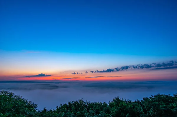 Aube par un matin brumeux sur une montagne au-dessus de la rivière — Photo