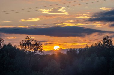 Gün batımı arka planında güç hattı telleri