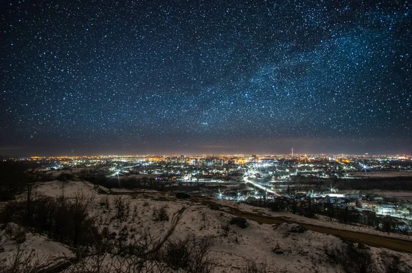 Ciudad por la noche contra el fondo del cielo estrellado — Foto de Stock