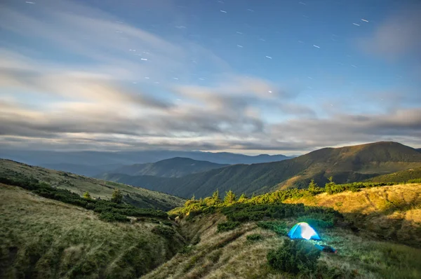 Panorama of the starry sky over the foggy mountains