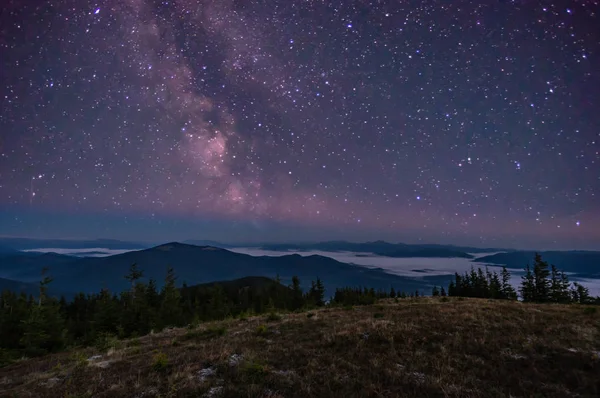 Panorama del cielo estrellado sobre las montañas brumosas — Foto de Stock