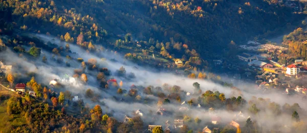 Panorama da cidade entre as montanhas no nevoeiro — Fotografia de Stock