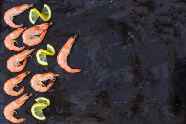 karides, limon ve deniz karanlık bir siyah arka plan üzerine tuz. Kopya alanı.