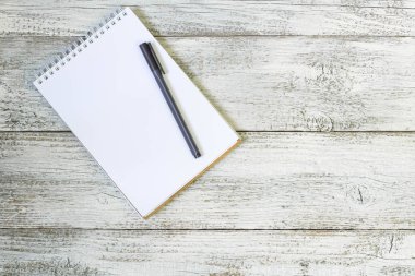 Kalem ve beyaz ahşap masa üstünde not etmek.