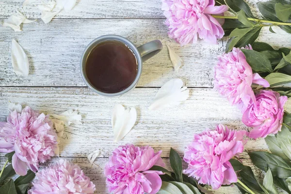 Çay Kupası ve peonies güzel natürmort. Üstten görünüm.