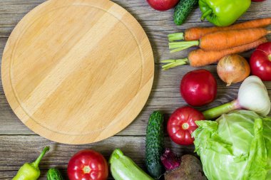 Daire kesme tahtası ve sebze ahşap arka plan üzerinde. Sağlıklı beslenme.