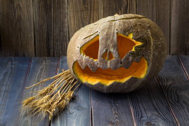 Fenerlerin valesi, tahta arka planda Cadılar Bayramı kabağı suratı.