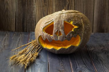 Fenerlerin valesi, tahta arka planda Cadılar Bayramı kabağı suratı.