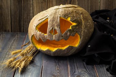 Fenerlerin valesi, tahta arka planda Cadılar Bayramı kabağı suratı.