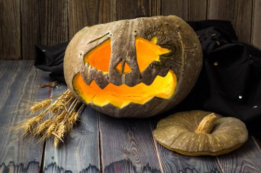 Fenerlerin valesi, tahta arka planda Cadılar Bayramı kabağı suratı.