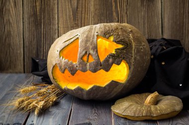 Fenerlerin valesi, tahta arka planda Cadılar Bayramı kabağı suratı.