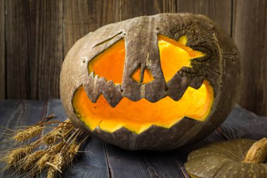 Fenerlerin valesi, tahta arka planda Cadılar Bayramı kabağı suratı.