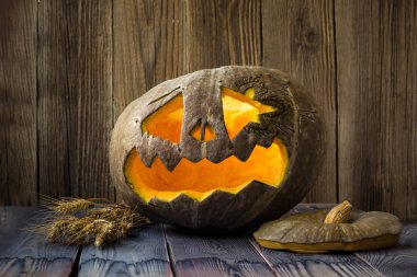 Fenerlerin valesi, tahta arka planda Cadılar Bayramı kabağı suratı.