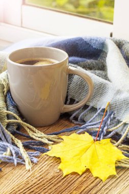 Natürmort tonda ekose ile bir fincan kahve ve sonbahar yaprakları