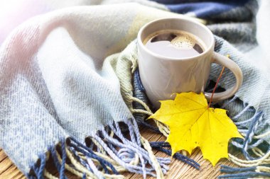 Natürmort tonda ekose ile bir fincan kahve ve sonbahar yaprakları