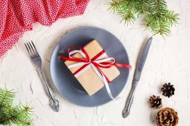 Beyaz masa üzerinde plaka üzerinde hediye ile Noel tablo ayarı. Xmas kavramı üstten görünüm.
