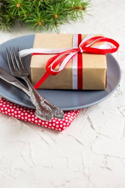 Beyaz masa üzerinde plaka üzerinde hediye ile Noel tablo ayarı. Xmas kavramı üstten görünüm.