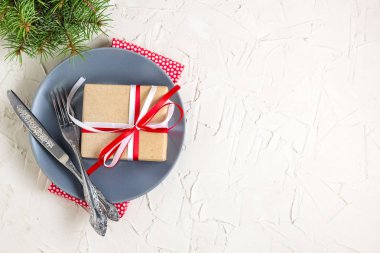 Beyaz masa üzerinde plaka üzerinde hediye ile Noel tablo ayarı. Xmas kavramı kopya alanı ile üstten görünüm.