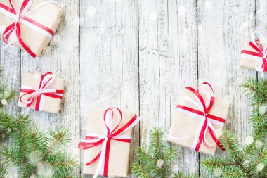 Sınır Noel hediye kutuları ve köknar ağacı dalı kar ahşap masa üzerinde. Kopya alanı ile üstten görünüm