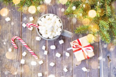 Sıcak kahve çikolata hatmi Noel ruh hali, rustik ahşap masa arka plan üzerinde şenlikli dekorasyon ile şeker hediye kutu kırmızı kurdele köknar ağacı kar ile dekore edilmiş köpekler.