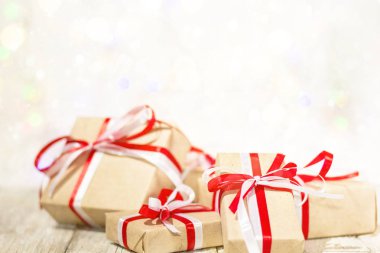 Noel hediye kutusu bokeh arka plana dayanır. Tatil tebrik kartı kar ile dekore edilmiştir..