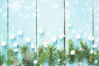 Çam ağacı ve ahşap arka plan üzerinde marshmallows dalı ile Noel sınır kar ile dekore edilmiştir. Üstten görünüm kopya alanı