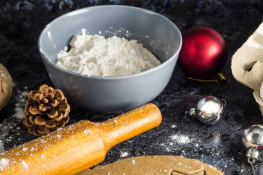 Noel gingerbread çerezleri karanlık bir arka plan üzerinde malzemelerle yemek.