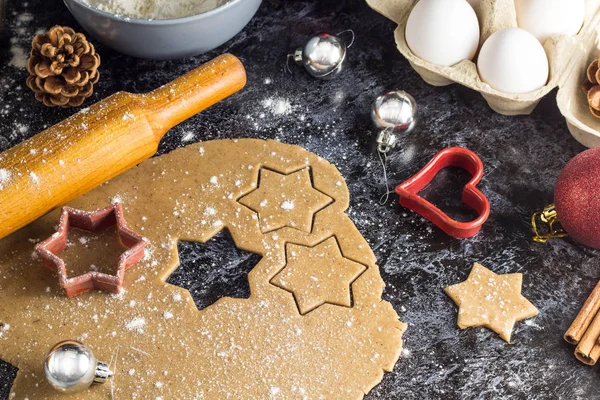 Cooking Christmas gingerbread cookies with ingredients on a dark background.