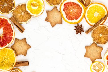 Çeşitli narenciye kurutulmuş dilimleri kenarlığını gingerbread meyve ve boşaltmak beyaz zemin üzerine baharat. Noel çerçeve