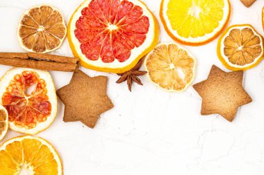 Çeşitli narenciye kurutulmuş dilimleri kenarlığını gingerbread meyve ve boşaltmak beyaz zemin üzerine baharat. Noel çerçeve