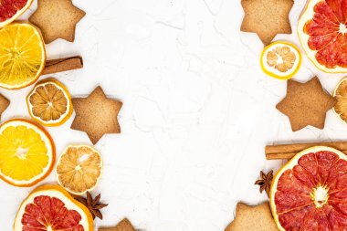 Çeşitli narenciye kurutulmuş dilimleri kenarlığını gingerbread meyve ve boşaltmak beyaz zemin üzerine baharat. Noel çerçeve