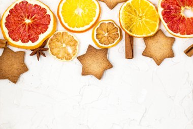 Çeşitli narenciye kurutulmuş dilimleri kenarlığını gingerbread meyve ve boşaltmak beyaz zemin üzerine baharat. Noel çerçeve