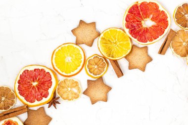 Çeşitli narenciye kurutulmuş dilimleri kenarlığını gingerbread meyve ve boşaltmak beyaz zemin üzerine baharat. Noel çerçeve