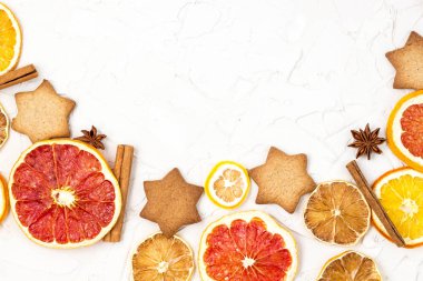 Çeşitli narenciye kurutulmuş dilimleri kenarlığını gingerbread meyve ve boşaltmak beyaz zemin üzerine baharat. Noel çerçeve