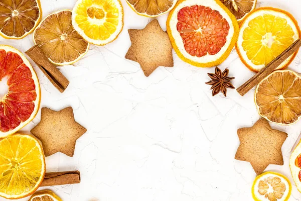Çeşitli narenciye kurutulmuş dilimleri kenarlığını gingerbread meyve ve boşaltmak beyaz zemin üzerine baharat. Noel çerçeve