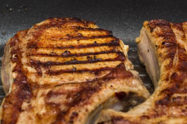 Taze domuz eti ızgara tava üzerinde hazırlanan kaburga ile büyük parça biftek