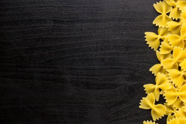 Farfalle makarna boşaltmak koyu siyah zemin üzerine yığını A sınır